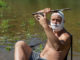 crazy or mad man shaves his head with machetes.